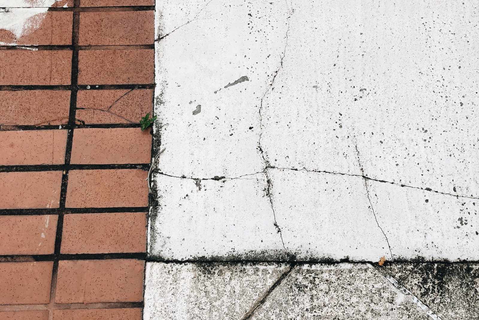 Sidewalk showing cleaned and dirty concrete side by side