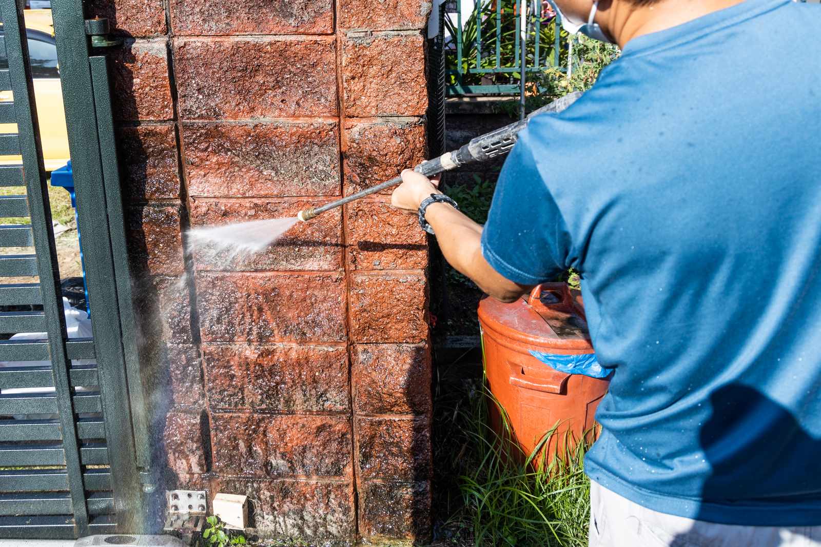 Moss and dirt being blasted off an exterior wall